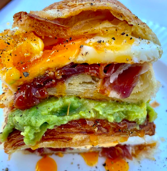 Cruasán relleno de huevo a la plancha, jamón ibérico y guacamole. 