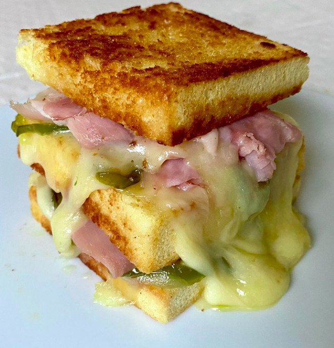 Sándwich de tres pisos relleno de queso crema y lacón gallego con pimientos verdes 🫑 confitados.